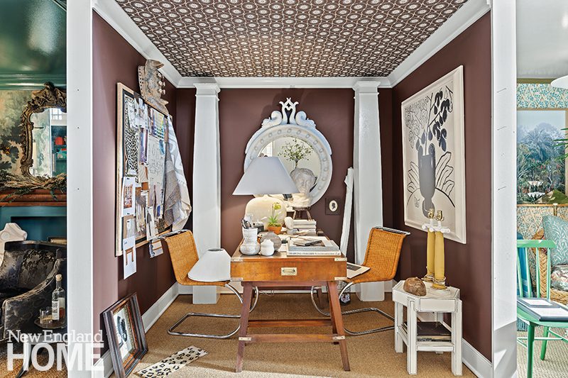 Stylish home office vignette by Patrick Mele featuring a patterned ceiling, rich brown walls, a vintage desk, eclectic art, and decorative accents with a classic touch.
