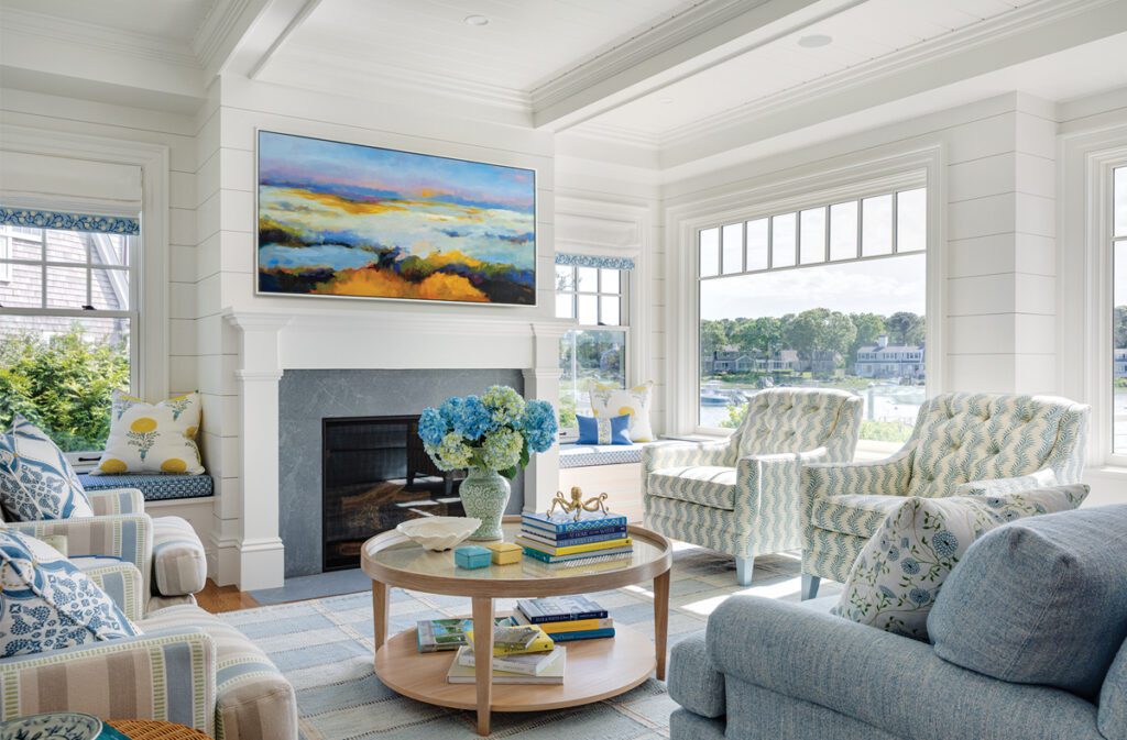 Coastal family room with shiplap walls, fireplace, blue upholstered furniture, and harbor views