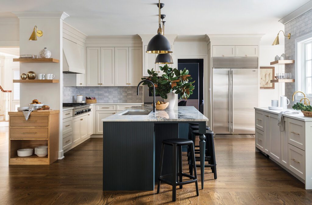 Transitional kitchen with navy island, pendant lighting, and creamy cabinetry with mixed metals