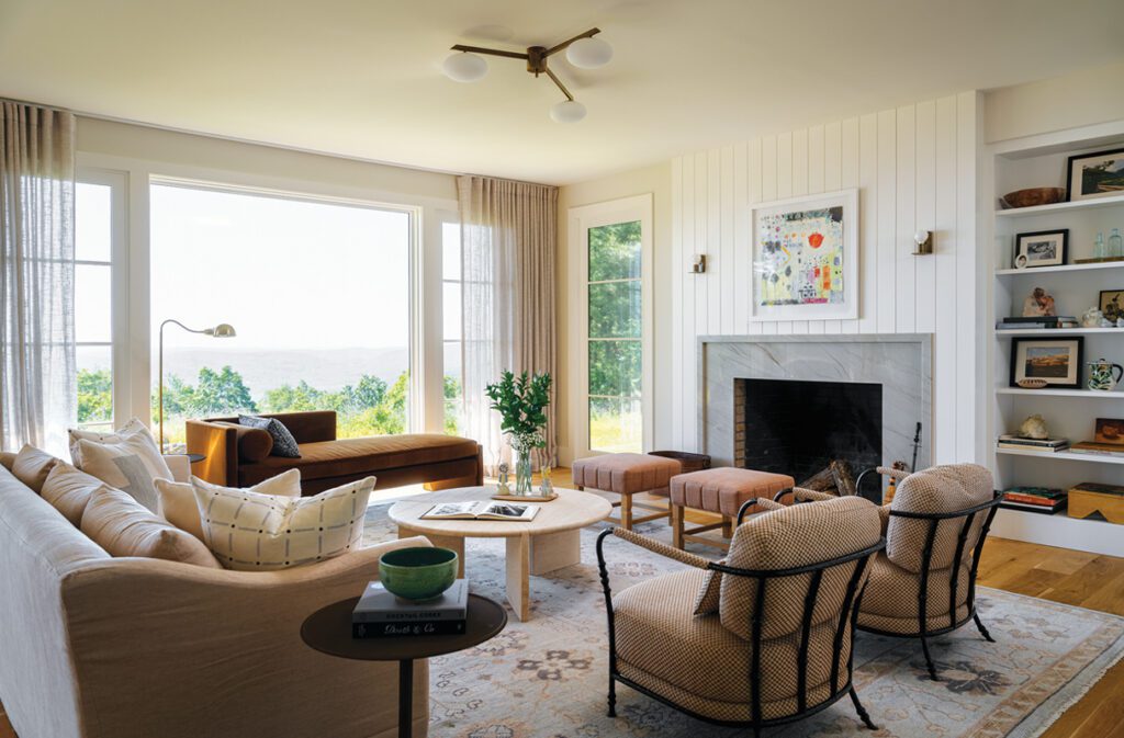Living room with fireplace, built-ins, and large windows overlooking water