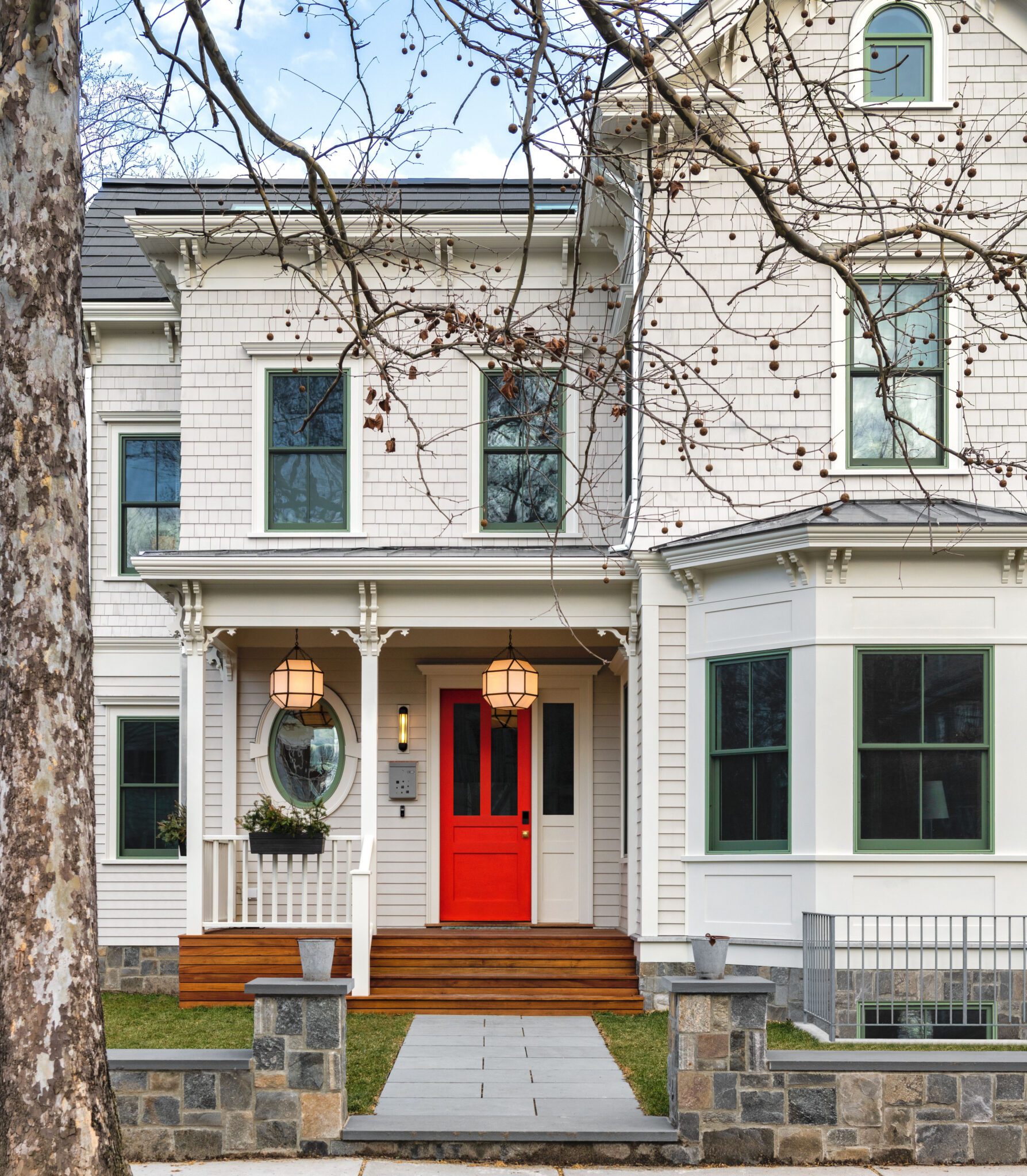 Historic New England home with white shingle siding and green double-hung replacement windows.